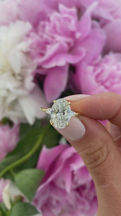 Em | Pear Cut Side Diamonds in Three Stone Engagement Ring